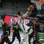 Giannis Antetokounmpo impulsa hacia la canasta contra el alero de Miami Heat Trevor Ariza (8) y el base Duncan Robinson (55) en el primer cuarto durante el segundo juego en la primera ronda de los Playoffs de la NBA de 2021