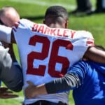 El corredor de los New York Giants, Saquon Barkley (26), es ayudado a salir del campo después de sufrir una lesión durante el segundo cuarto contra los Chicago Bears en el Soldier Field.