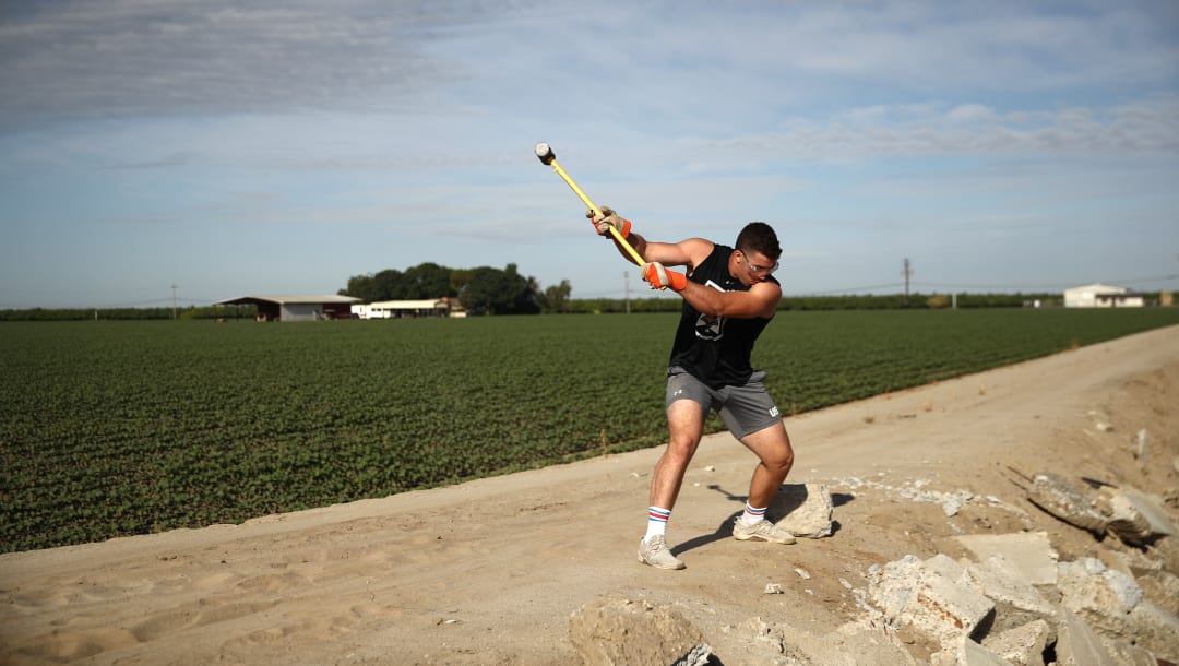 TULARE, CALIFORNIA - 6 DE JUNIO: El aspirante a boxeador olímpico Richard Torrez Jr.rompe cemento con un mazo durante una sesión de entrenamiento el 6 de junio de 2020 en Tulare, California.  Torrez Jr.fue uno de los 13 boxeadores seleccionados para representar al equipo de EE. UU. En los Clasificatorios de Boxeo de los Juegos Olímpicos de Tokio 2020 en Argentina, pero el clasificatorio fue cancelado debido al coronavirus.  El joven de 20 años ha ganado numerosos torneos internacionales y actualmente ocupa el quinto lugar en el mundo en la categoría de peso súper pesado.  El centro de entrenamiento en Colorado actualmente está cerrado por lo que Torrez Jr. continúa entrenando en casa con su padre, quien es su entrenador.  Su padre ha implementado muchos tipos diferentes de métodos de entrenamiento, como golpear rocas de cemento con un mazo, llenar los cilindros de las ruedas con arena y voltear los neumáticos de los tractores.  Los atletas de todo el mundo ahora se entrenan de forma aislada bajo estrictas políticas debido a la pandemia de Covid-19.  (Foto de Ezra Shaw / Getty Images)