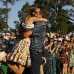 Scottie Scheffler levanta a su esposa Meredith Scudder después de ganar el 86° torneo de golf Masters el domingo 10 de abril de 2022 en Augusta, Georgia. (AP Photo/David J. Phillip)