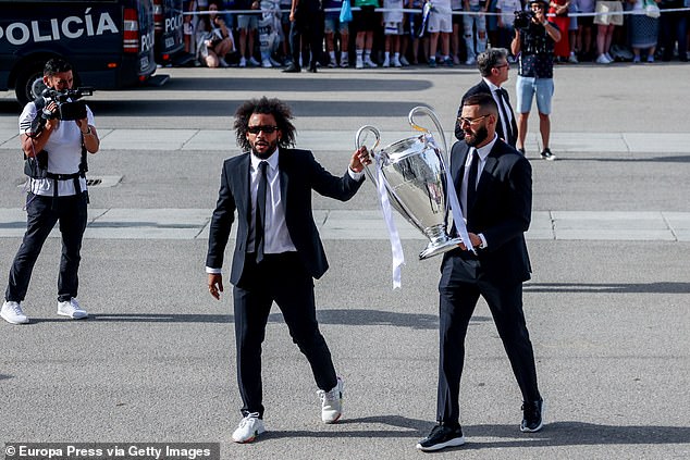 El capitán del Real Madrid Marcelo (izquierda) y Karim Benzema cargaron el trofeo de la Champions League