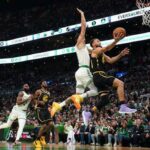 El jugador de los Golden State Warriors, Stephen Curry, conduce hacia la canasta mientras Jayson Tatum, de los Boston Celtics, intenta desafiarlo.