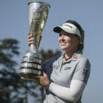 Brooke Henderson, de Canadá, celebra con su trofeo tras ganar el Campeonato de Evian.