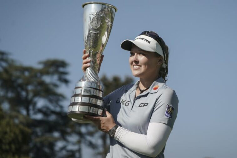 Brooke Henderson, de Canadá, celebra con su trofeo tras ganar el Campeonato de Evian.