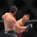 16 de julio de 2022;  Elmont, Nueva York, Estados Unidos;  Li Jingliang (guantes rojos) pelea contra Muslim Salikhov (guantes azules) durante UFC Fight Night en UBS Arena.  Crédito obligatorio: Ed Mulholland-USA TODAY Sports