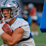 El corredor de los Carolina Panthers, Christian McCaffrey, lleva el balón durante un simulacro en el Fan Fest del equipo de fútbol de la NFL en Charlotte, NC, el jueves 11 de agosto de 2022.