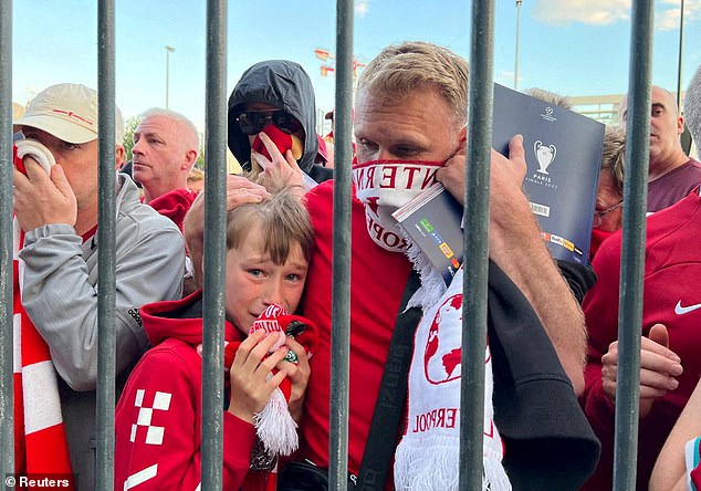 Los seguidores del Liverpool se protegen la cara para escapar de los gases lacrimógenos lanzados por la policía mientras hacían cola en condiciones casi aplastantes en la final de la Liga de Campeones en París en mayo.