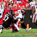 Tom Brady de los Tampa Bay Buccaneers es abordado por Grady Jarrett de los Atlanta Falcons (Foto de Julio Aguilar/Getty Images)