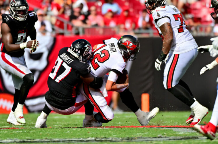 Tom Brady de los Tampa Bay Buccaneers es abordado por Grady Jarrett de los Atlanta Falcons (Foto de Julio Aguilar/Getty Images)