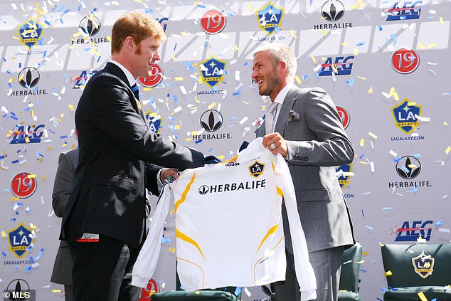 El entonces presidente del LA Galaxy, Alexi Lalas, le entrega a David Beckham su camiseta durante una conferencia de prensa que presenta a Beckham como el nuevo fichaje del club el 13 de julio de 2007.