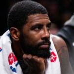 El escolta de los Brooklyn Nets, Kyrie Irving, se sienta en el banquillo