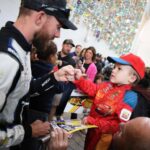 El piloto de NASCAR Ross Chastain firma autógrafos