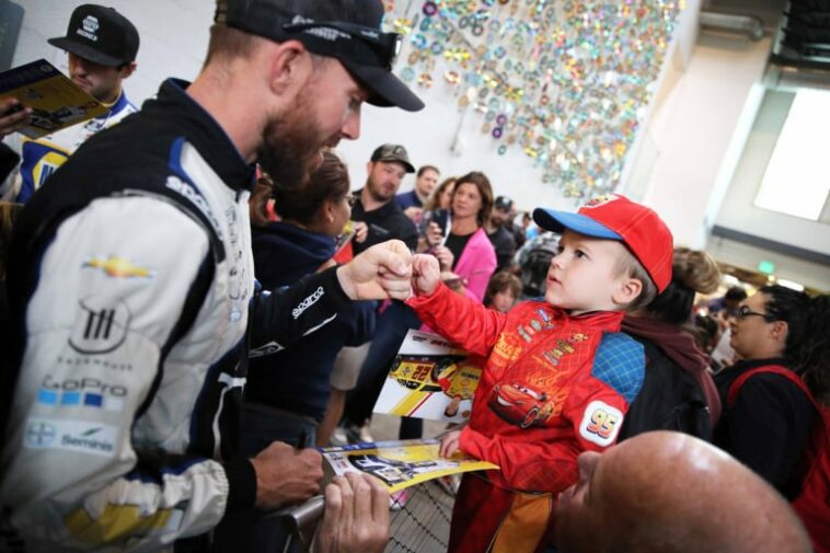 El piloto de NASCAR Ross Chastain firma autógrafos