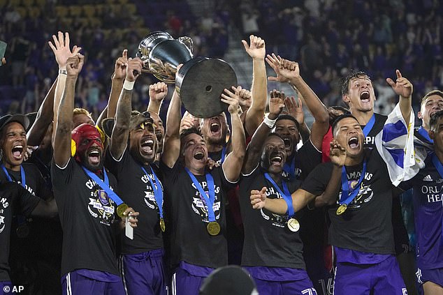 Los jugadores de Orlando City celebran mientras sostienen el trofeo del campeonato después de derrotar a Sacramento en la final de la Copa Abierta de EE. UU.