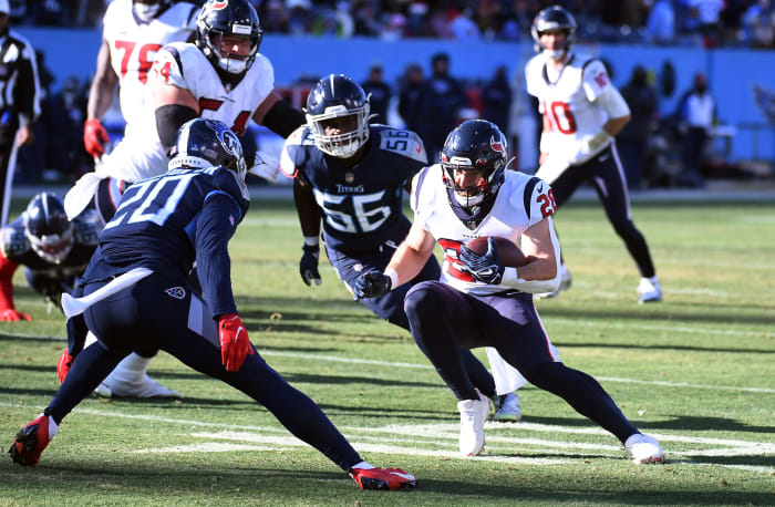 El corredor de los Houston Texans, Rex Burkhead, corre mientras los jugadores de los Titans se preparan para derribarlo.