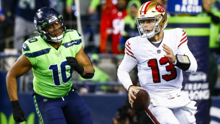 15 de diciembre de 2022;  Seattle, Washington, Estados Unidos;  El mariscal de campo de los San Francisco 49ers, Brock Purdy (13), se aleja del apoyador de los Seattle Seahawks, Uchenna Nwosu (10), durante el último cuarto en el Lumen Field.  Crédito obligatorio: Joe Nicholson-USA TODAY Sports