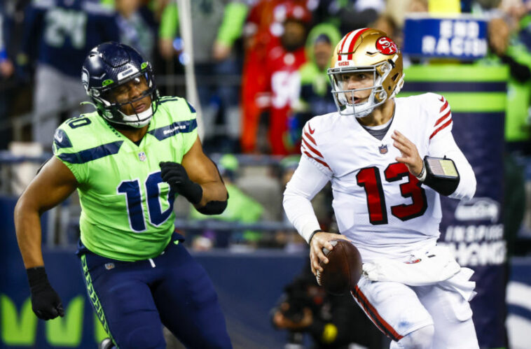 15 de diciembre de 2022;  Seattle, Washington, Estados Unidos;  El mariscal de campo de los San Francisco 49ers, Brock Purdy (13), se aleja del apoyador de los Seattle Seahawks, Uchenna Nwosu (10), durante el último cuarto en el Lumen Field.  Crédito obligatorio: Joe Nicholson-USA TODAY Sports