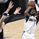 Kyrie Irving (derecha) realiza un tiro en suspensión durante su debut con los Dallas Mavericks