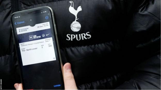 Un aficionado del Tottenham enseña su entrada digital en su móvil