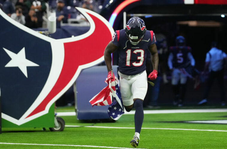 Brandin Cooks #13 de los Houston Texans entra al campo con una bandera estadounidense durante las presentaciones contra los New York Jets antes de un partido de la NFL en el NRG Stadium el 28 de noviembre de 2021 en Houston, Texas.  (Foto de Cooper Neill/Getty Images)