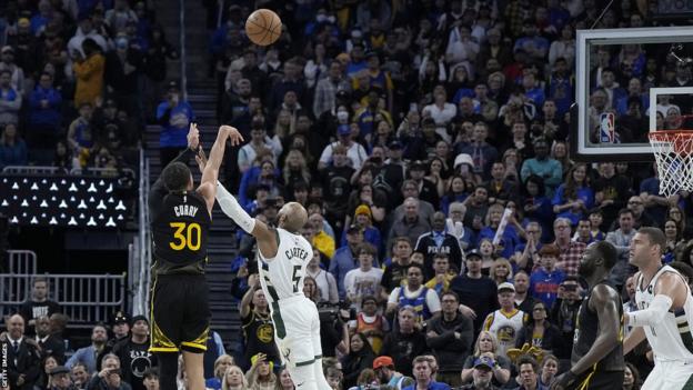Stephen Curry de los Golden State Warriors mete un triple para empatar el partido contra los Milwaukee Bucks