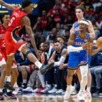 El guardia del Oklahoma City Thunder, Shai Gilgeous-Alexander, pasa el balón contra el delantero de los New Orleans Pelicans, Herbert Jones.