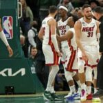 Max Strus celebra con sus compañeros y el personal del Miami Heat mientras Giannis Antetokounmpo observa