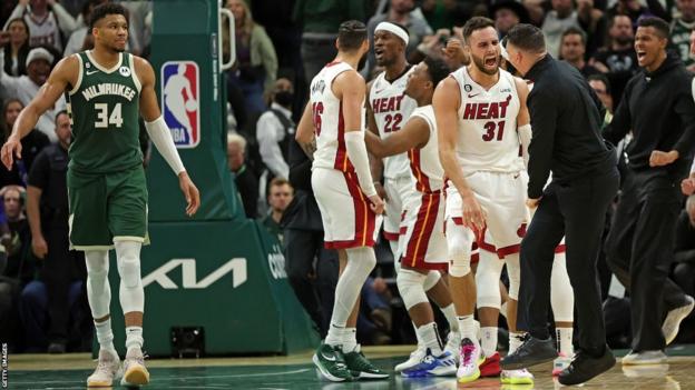 Max Strus celebra con sus compañeros y el personal del Miami Heat mientras Giannis Antetokounmpo observa