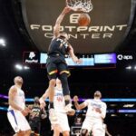 Devin Booker mojando la pelota con tres jugadores de Los Angeles Clippers mirando