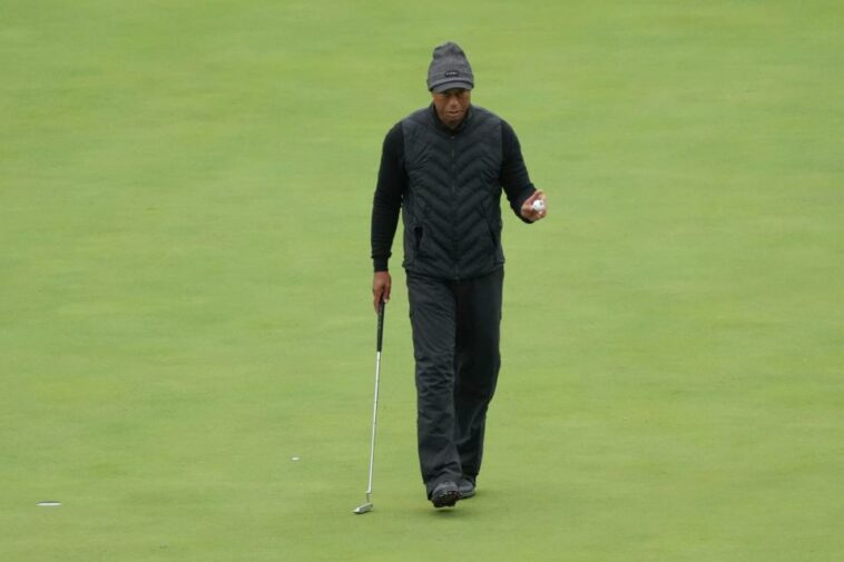 Tiger Woods reconoce a los patrocinadores después de un putt en el undécimo green durante la tercera ronda.