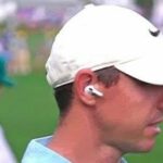 Rory McIlroy usando un auricular-micrófono para una entrevista de caminar y hablar en el Masters