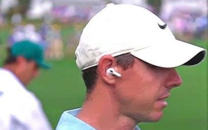 Rory McIlroy usando un auricular-micrófono para una entrevista de caminar y hablar en el Masters