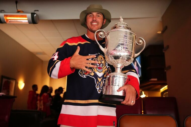 El golfista profesional Brooks Koepka posa con el Trofeo Wanamaker mientras asiste al tercer juego de las Finales de la Conferencia Este de los Playoffs de la Copa Stanley 2023 entre los Florida Panthers y los Carolina Hurricanes en FLA Live Arena.