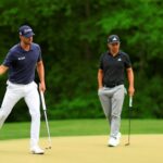 Wyndham Clark, a la izquierda, reacciona al hundir un putt para birdie en el hoyo 12 en su camino hacia la victoria en el Campeonato PGA Wells Fargo mientras el subcampeón Xander Schauffele observa