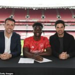 Bukayo Saka posa junto al director deportivo del Arsenal, Edu (izquierda) y el entrenador Mikel Arteta (derecha) después de firmar un contrato de £ 300,000 por semana hasta 2027