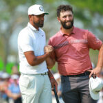 Finau y Rahm se dan la mano en el hoyo 18