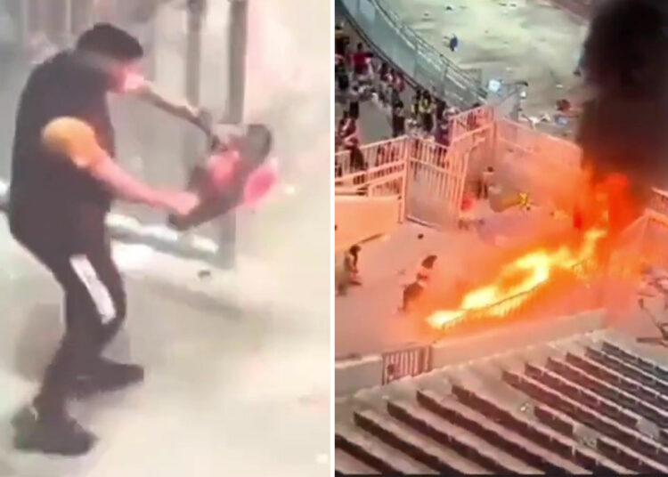 Momento impactante: un fanático pasea por el stand con CHAINSAW mientras los disturbios dejan el estadio en llamas durante el partido de fútbol