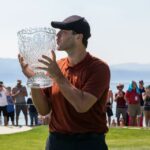 Tony Romo besa el trofeo del campeonato después de la ronda final del torneo de golf American Century Celebrity Championship en el campo de golf Edgewood Tahoe en Stateline, Nevada, el domingo 10 de julio de 2022. (Foto AP/Tom R. Smedes)