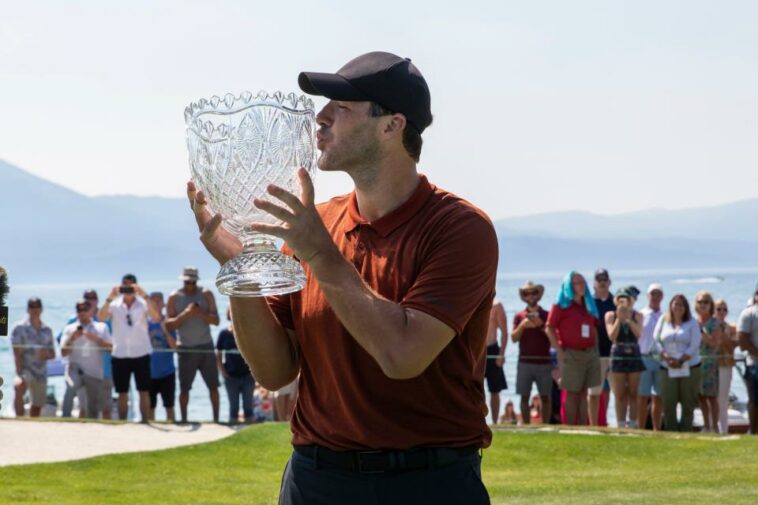 Tony Romo besa el trofeo del campeonato después de la ronda final del torneo de golf American Century Celebrity Championship en el campo de golf Edgewood Tahoe en Stateline, Nevada, el domingo 10 de julio de 2022. (Foto AP/Tom R. Smedes)