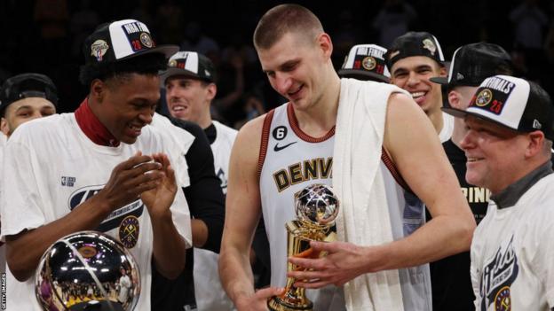 Nikola Jokic celebra con sus compañeros de equipo al recibir el trofeo de Jugador Más Valioso después de que los Denver Nuggets ganaran las Finales de la Conferencia Oeste de la NBA en 2023