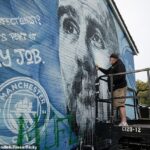 El artista Murwalls, también conocido como Marc Silver (en la foto), repara un vandalismo en el mural de Pep Guardiola fuera del estadio Etihad.