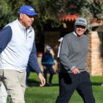 El comisionado del PGA Tour, Jay Monahan, sonríe al director ejecutivo de American Express, Stephen Squeri, mientras se acercan al segundo green durante la primera ronda del torneo de golf The American Express en La Quinta Country Club en La Quinta, California, el jueves 19 de enero de 2023.