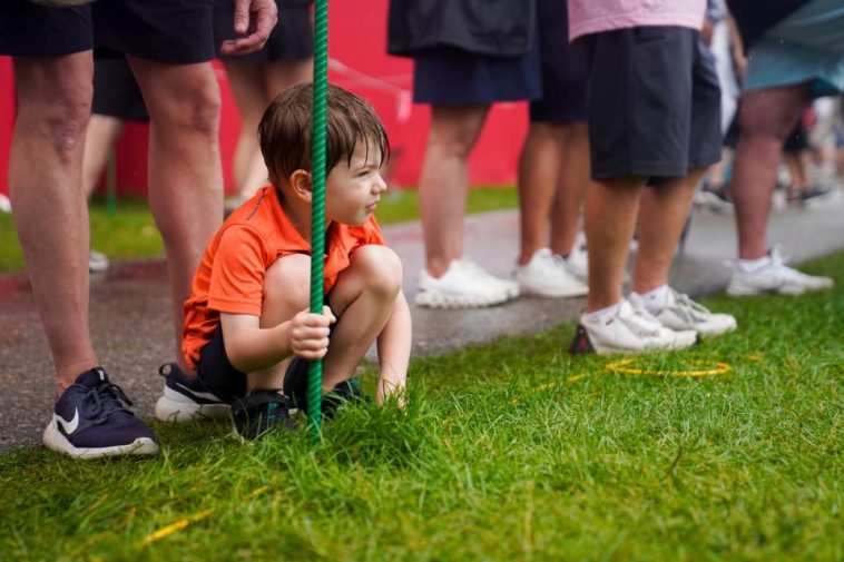 Tommy Johnson, de 5 años, espera a que Rickie Fowler llegue al hoyo 15 durante la cuarta ronda del Rocket Mortgage Classic en el Detroit Golf Club el domingo 2 de julio de 2023. Johnson usó su camiseta naranja para combinar con Fowler.