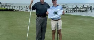 Bentley Van Pelt (derecha), del oeste de Florida, recibe la bandera del campeonato de manos del director ejecutivo de First Tee Gulf Coast, Marty Stanovich (izquierda), en el green 18 del Pensacola Country Club después de ganar la 15.ª edición anual de la Copa A. Downing Gray el martes 30 de julio de 2024.