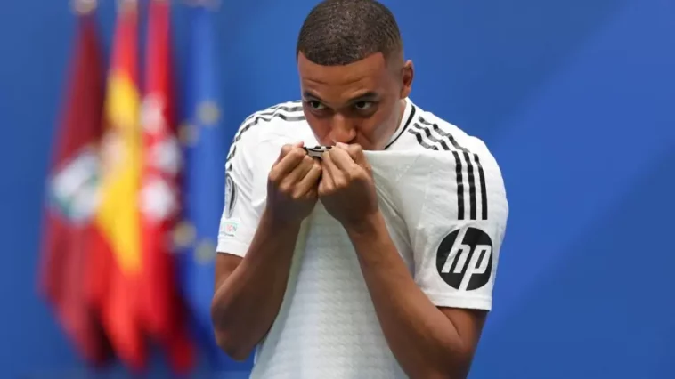 French forward Kylian Mbappe kisses his jersey during his first appearance as a Real Madrid player at the Santiago Bernabeu Stadium in Madrid on July 16, 2024, after signing his new five-season contract.