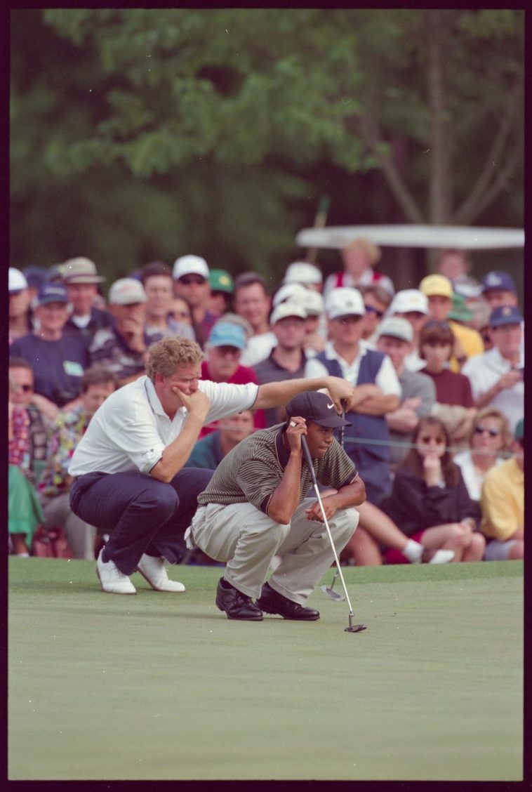 Tiger Woods se prepara para el putt con Colin Montgomerie observándolo detrás de él durante el Masters de 1997.