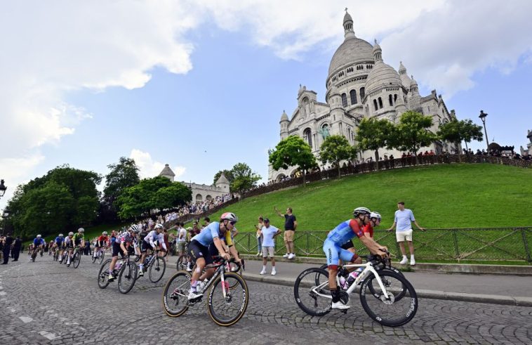 Los ciclistas descienden por debajo de la iglesia del Sacré Coeur durante el recorrido de reconocimiento de la carrera en ruta de los Juegos Olímpicos de París