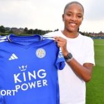 Shana Chossenotte holding up her Leicester shirt