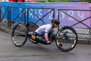 Oksana Masters compite por el equipo de EE. UU. durante los Juegos Paralímpicos de París en su bicicleta de mano con ruedas Zipp. Lleva un casco aerodinámico de carretera negro y una camiseta blanca del equipo de EE. UU.