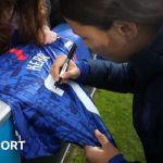 Sam Kerr signing a shirt